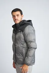 Campera puffer para hombre, color negro con canesú gris, capucha desmontable, cierre frontal con cremallera, bolsillos laterales con cierre y logo de la marca en el pecho.