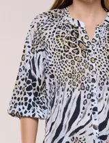 Blusa de gasa de color lila con calce holgado, cuello a la base con escote en V y cartera de botones a tono. Cuenta con fruncidos en el cuello y hombros que otorgan volumen, manga tres cuartos estilo abullonado con puño elastizado y ruedo suavemente redondeado.
