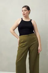 Pantalón de tiro medio con silueta amplia y estructura firme, confeccionado en algodón. Presenta detalle de ojalillos metálicos decorativos en los laterales.