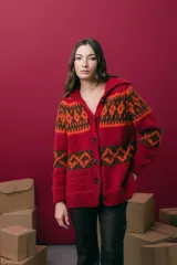 Saco tejido a mano con diseño jacquard, de corte recto y largo a la cadera. Presenta cuello tipo polo, cierre frontal con botones y mangas largas. Posee tajos laterales en el ruedo.