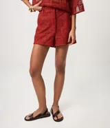 Short corto de crochet Marfinno color rojo, con diseño calado, bordado abstracto integral, aplicación de lentejuelas, pretina con pasadores y cierre delantero. Cuenta con forro interior.