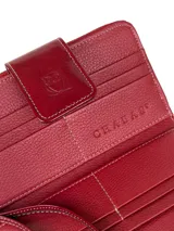 Billetera grande de cuero vacuno con textura granulada y detalles en charol. Cuenta con múltiples ranuras para tarjetas y cierre de solapa con broche a presión grabado con el logo de la marca.