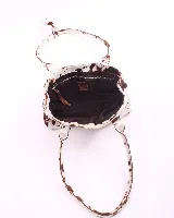 Cartera tipo baguette confeccionada en cuero vacuno con pelo y estampado animal print de vaca. Presenta doble asa de hombro, cierre superior y broches laterales para ajustar su volumen.