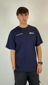 Remera de algodón color azul marino, con cuello redondo y mangas cortas. Presenta un estampado gráfico pequeño en el pecho con el logo de la marca y la frase 'Hopeless Romantic'.