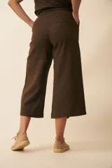 Pantalón palazzo marrón de tiro alto, con bolsillos laterales y largo a la pantorrilla.