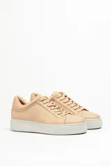 Zapatillas color beige claro, con capellada de cuero suave y acolchado, forro y plantilla de cuero vacuno, y suela de EVA. Tienen una plataforma de 3.8 cm en la parte trasera y 3.2 cm en la delantera.