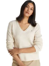Sweater de lana Tommy Hilfiger con cuello en V, mangas largas y terminaciones con dobladillos enrollados. Presenta el logo de la marca bordado en el pecho.