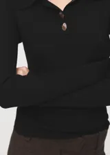 Jersey de punto color negro con cuello polo, cierre frontal parcial con botones y mangas largas.
