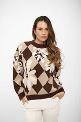 Buzo de tejido de punto con diseño de rombos y flores estampadas en tonos marrón y beige, de cuello redondo y manga larga.