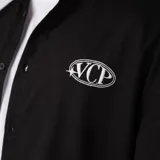 Camisa de manga corta color marfil, corte boxy, con cuello camisero, cierre frontal de botones y pequeño bordado marrón en el pecho con las siglas VCP.