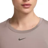 Remera deportiva Nike de manga corta, con cuello redondo y detalle de nudo frontal. Presenta un diseño corto y logo de la marca bordado en el centro del pecho.