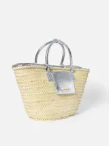 Bolso canasto Jacquemus Le Panier Soli tejido en fibra vegetal con detalles en cuero metalizado plateado, dos asas cortas de mano y bolsillo frontal con logotipo en letras doradas.