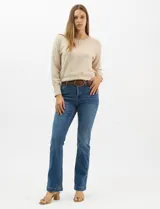 Jean de tiro alto con corte bootcut, color azul medio, con diseño de cinco bolsillos y costuras en contraste. Incluye un cinturón trenzado de cuero sintético con hebilla metálica.