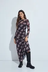 Falda larga de corte fluido con estampado de cuadros en tonos oscuros, rojizos y blancos. Presenta un diseño ligero con terminaciones onduladas en el ruedo.