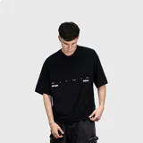 Remera negra de corte oversize con estampa gráfica en la espalda en color crema que incluye el texto 'WE ARE VENEFO' y una frase secundaria. Confeccionada en algodón de alta calidad.