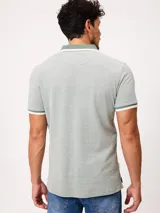 Remera polo de piqué de algodón melange color celeste, con cuello y puños en contraste blanco y azul, cierre frontal con botones y bordado pequeño en el pecho.