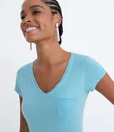 Remera básica de algodón color verde claro con escote en V, manga corta y un pequeño bolsillo frontal en el pecho.