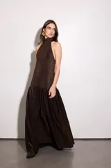 Vestido largo color cobre con escote halter, espalda baja y falda acampanada.