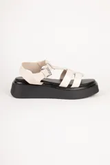 Sandalias de plataforma color beige con tiras de símil cuero texturizado y hebilla metálica ajustable.