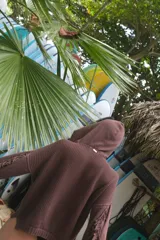 Buzo con capucha de tejido de punto abierto, color blanco roto, de corte oversize y manga larga con detalle de flecos en los puños.