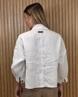 Sobrecamisa de lino color beige, con cuello camisero, cierre frontal de botones carey, mangas largas y bolsillos frontales con solapa.