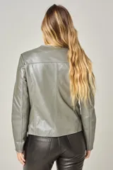 Campera clásica de cuero ovino color beige claro, con cuello a la base, cierre frontal y bolsillos laterales con cierre. Presenta costuras verticales que estilizan la silueta.