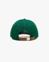 Gorra verde botella de estilo varsity, estructurada, con la inscripción frontal "NUDE Project" bordada en blanco. Presenta detalles de hojas bordadas en tono sobre tono sobre la visera.