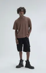 Remera de tejido de punto color café, con mangas cortas y cuello redondo. Presenta una textura calada y un calce ligeramente oversize.