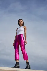 Pantalón de tiro alto confeccionado en bengalina engomada con acabado metálico brillante. Presenta un corte capri semi oxford con costura horizontal a la altura de la rodilla, cierre frontal con botón metálico y bolsillos funcionales.