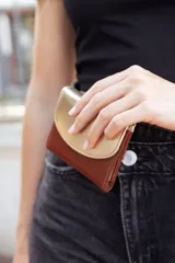 Billetera chica de cuero color marrón y dorado, con cierre de broche a presión.