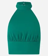 Top cropped de crepé color verde esmeralda, con escote halter y cuello alto. Presenta un canesú fruncido en la cintura que ajusta la prenda al cuerpo.