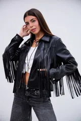 Campera de cuero sintético negro con flecos largos en la espalda y mangas. Presenta un diseño de estrellas pespunteadas en la parte superior de la espalda.