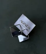 Aros colgantes plateados de diseño geométrico en miniatura, formados por una estructura de rombo y un aplique triangular sólido.