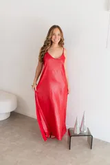 Vestido largo rojo brillante, con escote en V y tirantes finos. Presenta un corte holgado y abertura lateral en la falda.