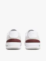 Zapatillas Tommy Hilfiger de running, color blanco con detalles en beige y burdeos. Confeccionadas en ante, poliéster y goma, con suela dentada de EVA y logo distintivo de la marca en el lateral y el talón.