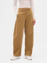 Pantalón de gabardina color marrón, con corte barrel de tiro medio y pierna ancha. Presenta cierre frontal con botón y bolsillos laterales.