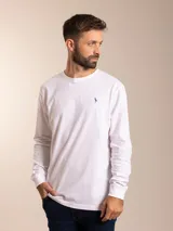 Remera blanca de manga larga con cuello redondo y logo bordado de un pájaro en el pecho.