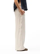 Pantalón de lino beige de corte holgado, con cintura elástica, dos bolsillos laterales y un bolsillo trasero.