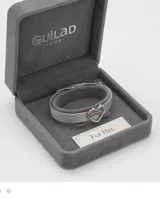 Pulsera de malla metálica plateada con dije central en forma de corazón que contiene la palabra mamá grabada.