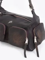 Cartera de hombro confeccionada en cuero vacuno color bordó con acabado desgastado. Presenta múltiples bolsillos exteriores con cierre en el frente, dorso y laterales, herrajes metálicos plateados y logo de la marca aplicado en el frente.