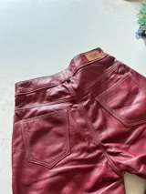 Pantalón slouchy de cuero ovino italiano color burdeos, corte mom fit con tiro semi alto, tajos inferiores y bolsillos laterales.