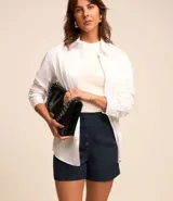 Short de sastrería negro, tiro alto, con cierre frontal de botones visibles.