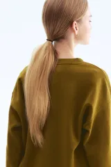 Buzo de tejido de punto color verde oliva, con cuello redondo y manga larga. Presenta un estampado frontal en blanco con texto en francés que dice "Ce soir on va danser" (Esta noche vamos a bailar).