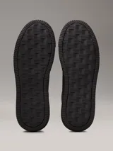 Zapatillas urbanas de cuero granulado color negro, con suela cupsole gruesa, interior de espuma, forro de malla de poliéster y logo de Calvin Klein en la lengüeta y el talón.