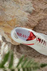 Zapatillas bajas de cuero color beige con detalles en animal print y suela blanca.