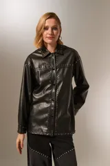Chaqueta negra de eco-cuero con cuello camisero, corte holgado, cierre con broches y tachas plateadas.