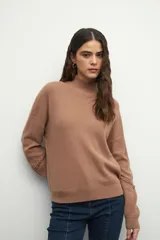 Polera tejida color borgoña, de cuello alto y mangas largas abullonadas con detalle de bordado trenzado en los puños.