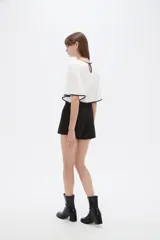 Short negro de poliéster, con pinzas, corte recto y tiro alto, con lazo ajustable en la cintura.