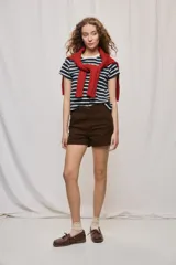 Short de tiro medio y calce ajustado, color blanco, con dobladillos en las piernas y cierre frontal con botón.
