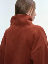 Campera de tela fleece doble, color negro, con cierre frontal completo, cuello alto y bolsillos laterales. Presenta puños y bajo elastizados para un ajuste cómodo.